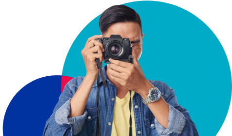 Man in denim jacket taking a picture with an SLR